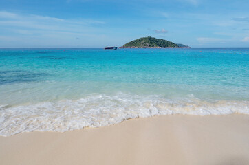 Beautiful beach and tropical sea with wave crashing on sandy shore Small island archipelago at Similan national park Thailand travel and tour concept