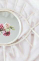 Beautiful eustoma flower reflected in mirror on background of soft fabric. Womens day. Gentle image