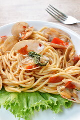 spicy stir fried spaghetti calms with pepper and basil leaf on plate