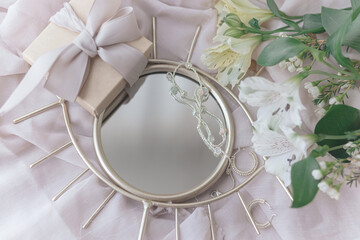 Happy Womens and Mothers day. Stylish gift, jewelry, spring flowers on boho mirror on soft fabric