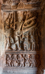 Fototapeta na wymiar Badami, Karnataka, India - November 7, 2013: 2nd Cave temple above Agasthya Lake. Sculpture of Vishnu as Trivikrama taking first step. Legend of Vamana dwarf under leg,