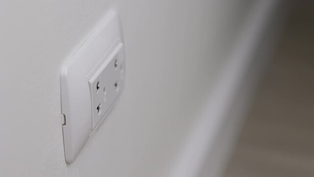Hand remove Electric plug on socket. Electrical equipment, electrical wires and power strips in the house. Earth Hour saving electrical energy.