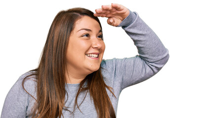 Beautiful brunette plus size woman wearing casual clothes very happy and smiling looking far away...