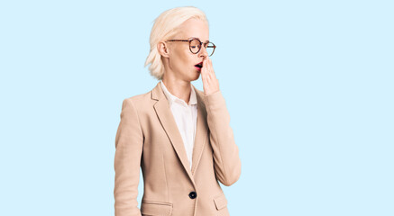 Young blonde woman wearing business clothes and glasses bored yawning tired covering mouth with hand. restless and sleepiness.