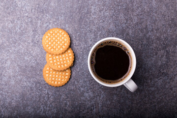 top view of cup of a coffee with three butter biscuits