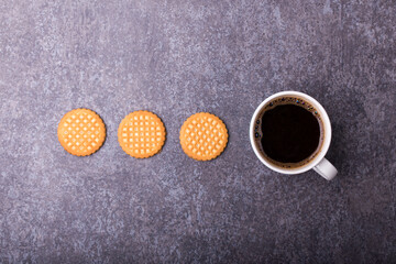 Obraz na płótnie Canvas top view of cup of a coffee with three butter biscuits