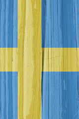 The flag of Sweden on a dry wooden surface, cracked with age. Light pale faded paint. Vertical background or wallpaper. Scandinavian cross. Annual rings of old wood. Direct hard sunlight with shadows
