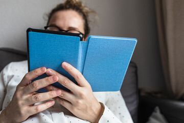 Relaxed woman reads with ebook at home.