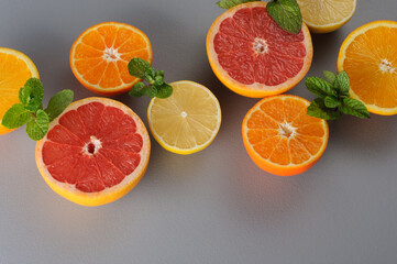 Cut in half fresh citrus fruits on gray background. Citrus juice ingredients, food background. preparation of drinks