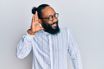 Young african american man wearing business style smiling with hand over ear listening and hearing to rumor or gossip. deafness concept.