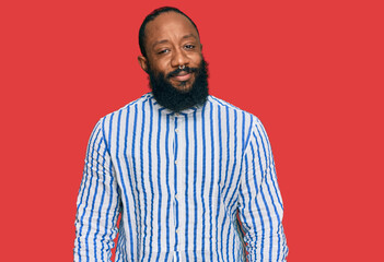 Young african american man wearing business shirt relaxed with serious expression on face. simple and natural looking at the camera.