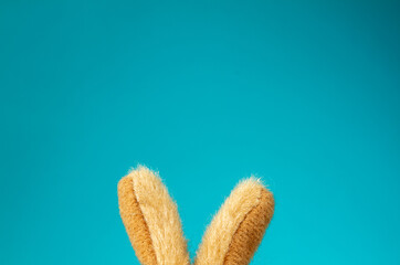 Toy Easter bunny ears on blue background with copy space.