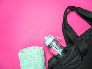Filter water bottle in a training bag and towel. Fitness flat lay composition with copy space on...