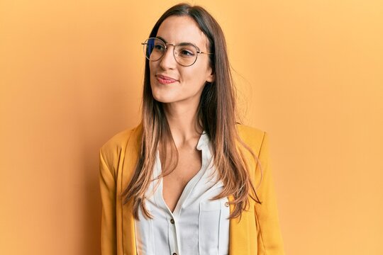 Young beautiful woman wearing business style and glasses smiling looking to the side and staring away thinking.