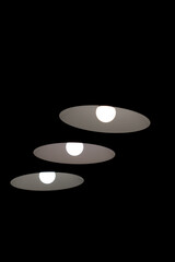 Vertical banner with three minimalistic lamps on black ceiling background