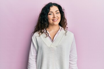 Young brunette woman with curly hair wearing casual clothes with a happy and cool smile on face. lucky person.