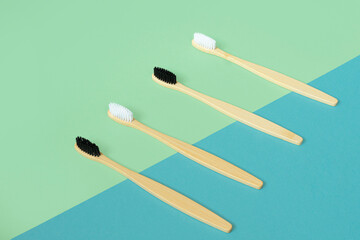 family set of four wooden bamboo toothbrushes for the whole family on a modern blue and green background. Concept for a natural organic oral care product. Zero waste concept. A future without plastic