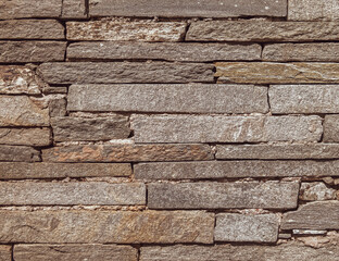 rough brown slate stone wall closeup, textured pattern background