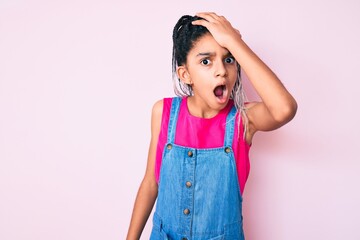 Young african american girl child with braids wearing casual clothes over pink background surprised with hand on head for mistake, remember error. forgot, bad memory concept.