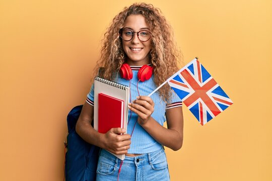 Beautiful caucasian teenager girl exchange student holding uk flag smiling with a happy and cool smile on face. showing teeth.