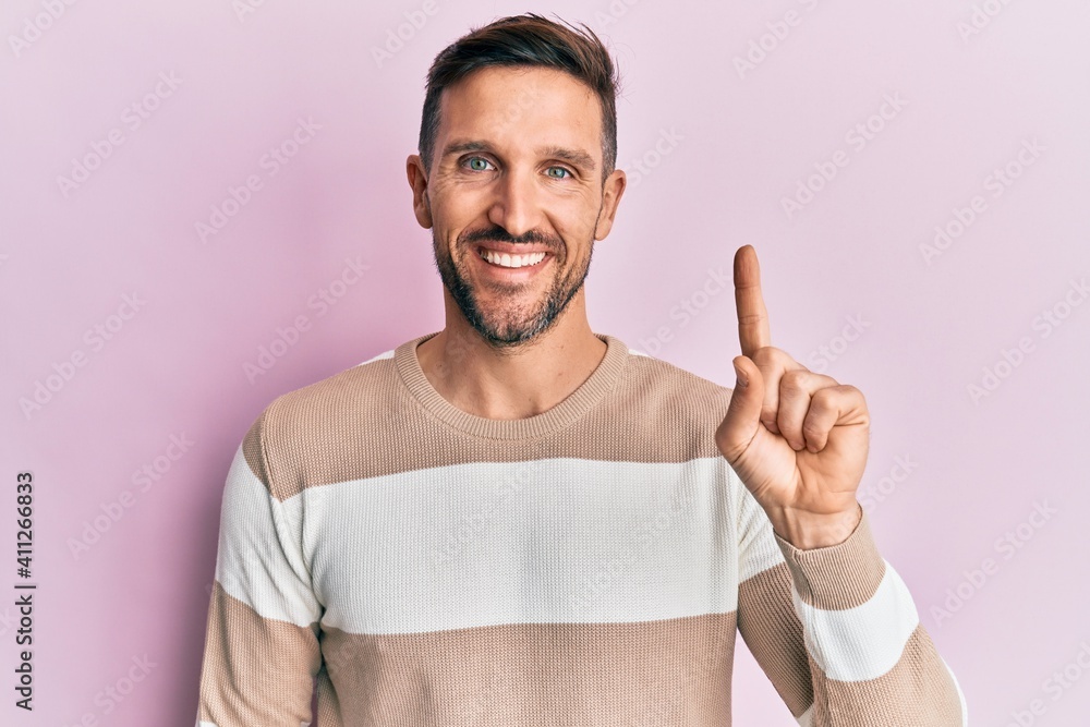 Sticker Handsome man with beard wearing casual clothes smiling with an idea or question pointing finger up with happy face, number one