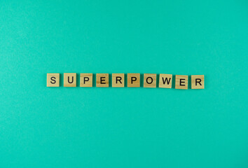 Word Superpower. The phrase is laid out in wooden letters. Top view. Motivation. Blue background. Copy space