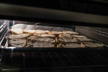 Slices of fresh white bread are being baked in oven. Closeup. 