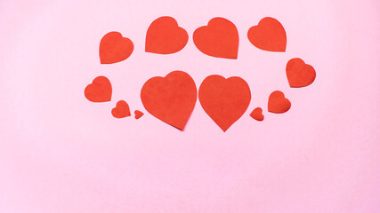 Red hearts on light pink background. Greeting card.