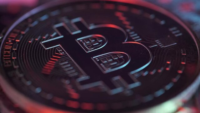 Single Crypto Currency Bitcoin Rotating Under Colorful Lights. Block Chain Technology. New Era of Digital Banking, Finance and E-Commerce.