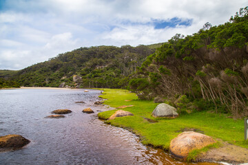 Australian landscape in November with stones, blue sky, mountains and bush.