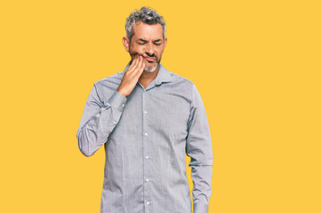 Middle age grey-haired man wearing casual clothes touching mouth with hand with painful expression because of toothache or dental illness on teeth. dentist