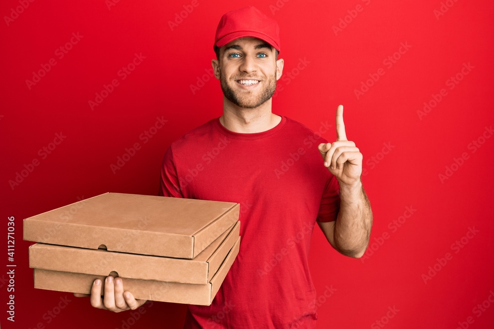 Sticker young caucasian man holding delivery pizza box smiling with an idea or question pointing finger with