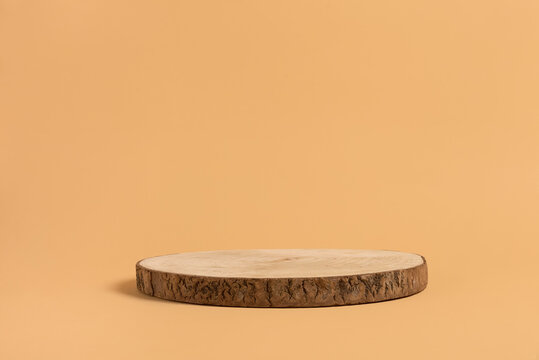 Round wooden saw cut cylinder shape for product presentation on a beige background. Round geometric shape of the cylinder. eco style and minimalism. Wooden slice.