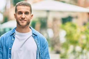 Young caucasian man smiling happy standing at the city.