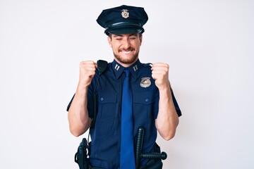 Young caucasian man wearing police uniform excited for success with arms raised and eyes closed celebrating victory smiling. winner concept.