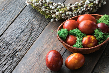 Painted Easter eggs in onion husks with abstract drawings are in a basket