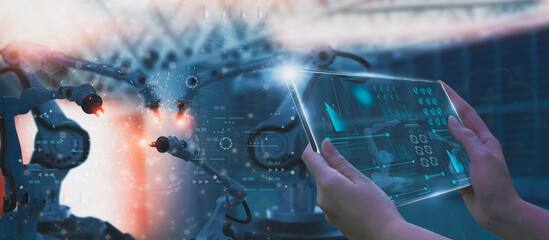 Industry engineer in factory,using smart tablet glass device,control automated robot arm machine learning operation,concept business and industry 4.0,Artificial intelligence or AI,with 5G network