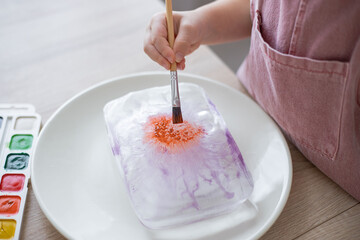 Child explore the ice, painting with colours. Home made activity, creativity for toddlers.