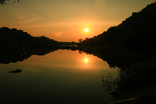 Symmetrical sunset reflected in lake, Indai