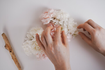 A bouquet of delicate flowers White carnations spring bouquet on a white background, hands collect a bouquet