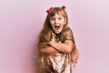 Little caucasian girl kid wearing festive sequins dress happy face smiling with crossed arms...
