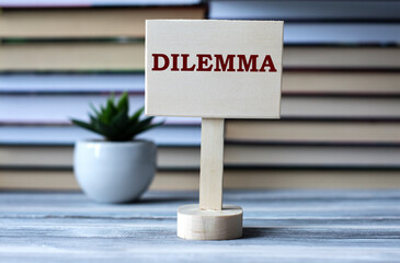 DILEMMA - words on the information board against the background of a stack of books