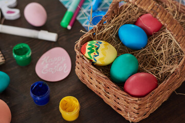 Close-up of basket with Easter painted eggs on the table preparing for holiday