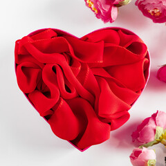 Red heart shaped gift box and flowers on white background