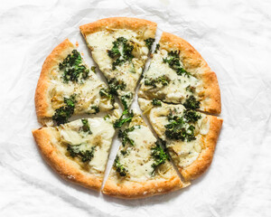 Slice of vegetarian potato, kale cabbage, mozzarella cheese pizza on a light background, top view