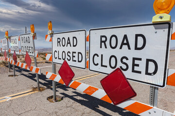 Road closed signs blocking remote Mojave desert highway in scenic Southern California.