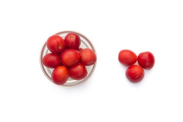 Group of red wild cherry plums in the glass vase isolated on the white background.