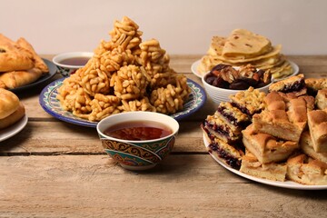 Traditional Tatar Cuisine On Wooden Table. Kystybyi, Echpochmak, Peremech, Chak Chak, Belesh, Tea In Piala, Dried Fruits And Nuts. Top View.