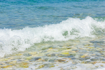 Sea wave and pebble. Summer vacation concept. Sea wave with foam incident on the coastal shingle. Travel concept