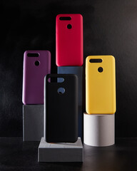 colorful cases for modern smartphones stand on stands on the table side view blurred background